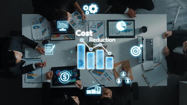 Aerial view of a business meeting focused on cost reduction strategies, featuring charts and digital icons that represent efficiency and productivity in a corporate environment. Raster