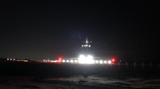 Stockholm, Sweden A commercial airplane lands at night in winter at Arlanda Airport. 