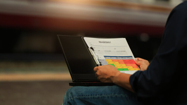 Focused male professional holding document and performing risk assessment analysis clipboard with serious concentration and careful attention
