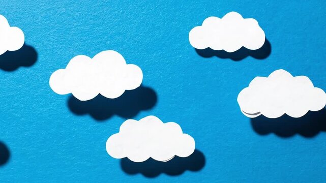 Whimsical white paper cut-out clouds casting soft, natural shadows across a vibrant blue background, evoking a peaceful and dreamy sky scene ideal for creative projects and atmospheric design