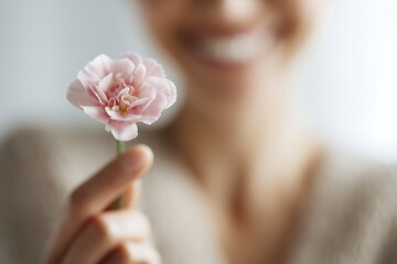 Fototapeta premium Woman offering pink carnation flower smiling