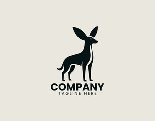 Fototapeta premium Black vector logo dog standing in alert pose with large floppy ears and slim body proportions