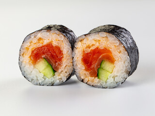 Two fresh salmon and cucumber maki sushi rolls isolated on a white background. © Andrei Starostin