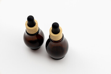 Amber Glass Dropper Bottles with Wooden Caps on White Background