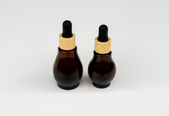 Amber Glass Dropper Bottles with Wooden Caps on White Background