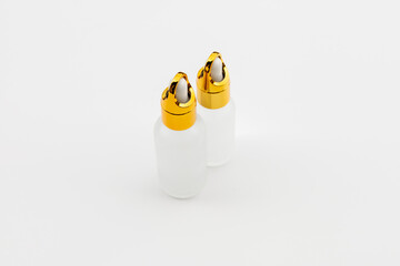 Minimal Frosted Glass Serum Bottle with Gold Dropper Cap on White Background