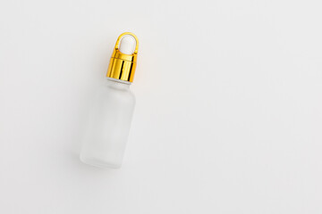 Minimal Frosted Glass Serum Bottle with Gold Dropper Cap on White Background