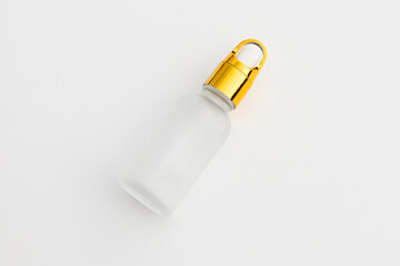 Minimal Frosted Glass Serum Bottle with Gold Dropper Cap on White Background