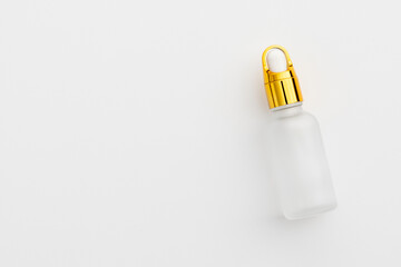 Minimal Frosted Glass Serum Bottle with Gold Dropper Cap on White Background