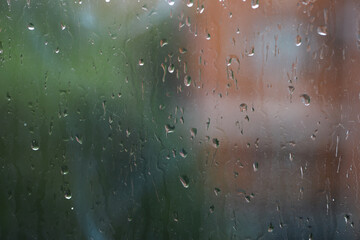 Obraz premium Rainy Window View: Blurred Nature and Urban Background with Raindrops