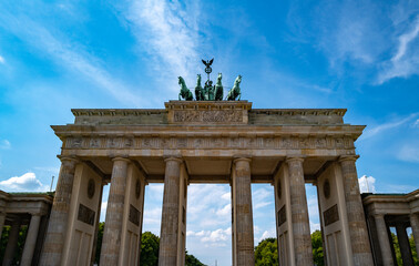 Obraz premium History Brandenburg gate in Berlin under the blue sky. The famous Brandenburg gate in Berlin symbol of peace. Berlins landmark. Architecture in Berlin Germany.