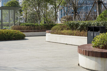 Urban park plaza with paved walkways, greenery, and modern seating facilities © zhu difeng