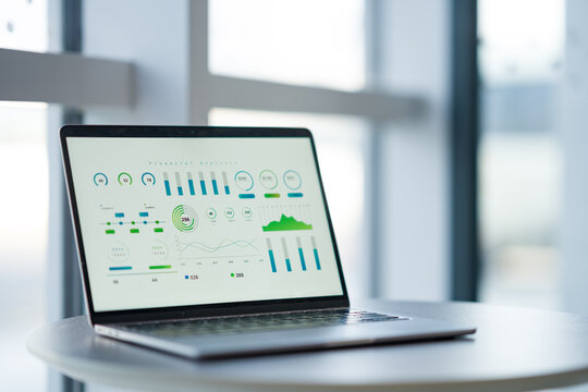 Laptop displaying data visualization dashboard with charts and analytics on screen