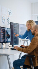 Analyzing Code: A mentor guides a colleague through lines of code, illustrating collaboration and the problem-solving mindset intrinsic to the tech industry.