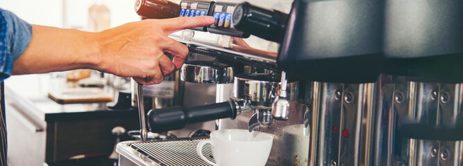 Banner Close up hands coffee barista man make hot cup espresso shot from coffee machine. Banner man hands of barista make black hot Cappuccino milk coffee cup with copy space