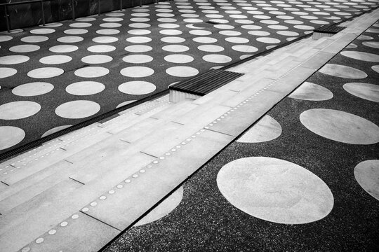 Monochrome pavement pattern of circles forming abstract geometry texture in urban space delivering clean design background and graphic surface for layouts