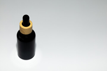 Minimal Black Cosmetic Serum Container on Neutral Surface