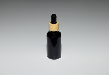 Minimal Black Cosmetic Serum Container on Neutral Surface