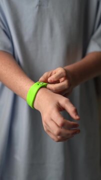 A teenager in a hotel room puts on an RFID or NFC bracelet. A boy puts on a contactless bracelet on his wrist. High quality FullHD footage