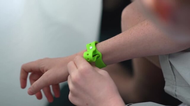 A teenager in a hotel room puts on an RFID or NFC bracelet. A boy puts on a contactless bracelet on his wrist. High quality FullHD footage