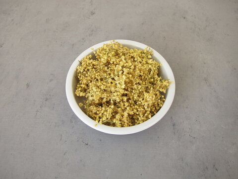Dried elderflowers in a porcelain bowl for herbal tea - natural herbal remedy and traditional home medicine from black elder shrub