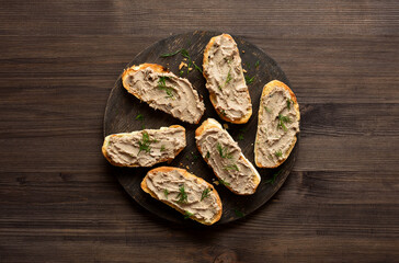 Appetizer liver pate on toasted bread on cutting board