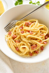 Italian pasta dish with crisp pancetta, parmesan cheese and black pepper