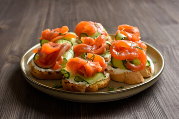 Smoked salmon toasts with cream cheese, fresh cucumber and greens