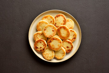 Cottage cheese pancakes on plate on dark background