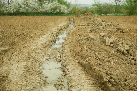 Soil erosion damage field agriculture subsoil result of deep wheel track likely tractor or heavy machinery vehicle hard heavy equipment during spring inappropriate management of earth land landscape