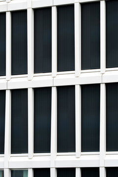 Abstract urban architecture detail of building windows and modern facade with grid pattern delivering minimal structured background
