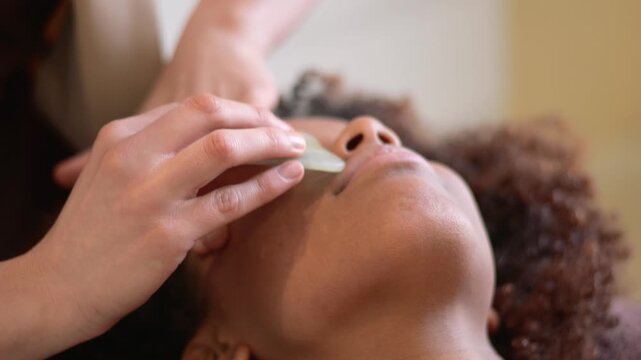 Esthetician performing relaxing gua sha chinese facial massage