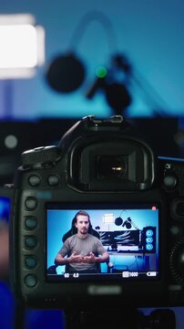 Tech influencer shooting video with photo camera