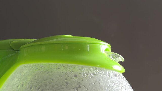 An electric kettle is activated with a distinct mechanical click. As the internal heating element warms, the water begins to rumble and hiss, eventually reaching a loud, vigorous boil.