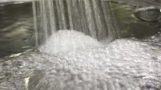 Many high-pressure jets of water stream from a tap into a basin. The multiple streams collide with the water surface to create a loud, roaring splash sound. Bubbles and foam form rapidly