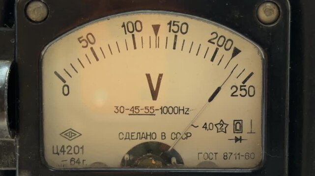 An vintage Soviet voltmeter monitors electrical fluctuations on a worn yellow dial. This mechanical process produces a deep, low-frequency humming sound.