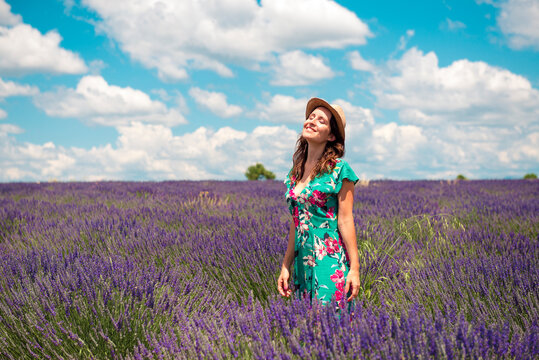 France, Provence, Valensole plateau, happy woman with straw hat standning in lavender field