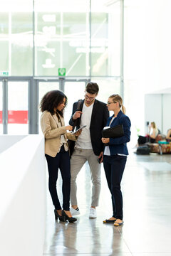 Young business people using a tablet in a foyer