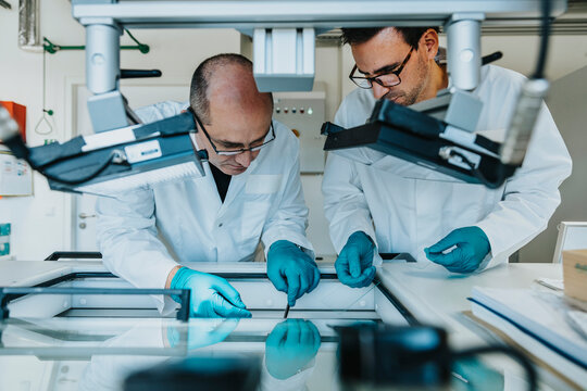Male scientists preparing human brain slice while standing by freezer at laboratory