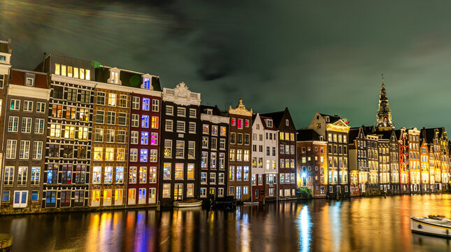 Amsterdam city at night. Old water canal houses in Netherlands. Citiscape panorama