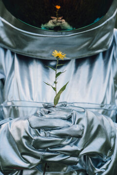 Spaceman holding flower, watching it grow