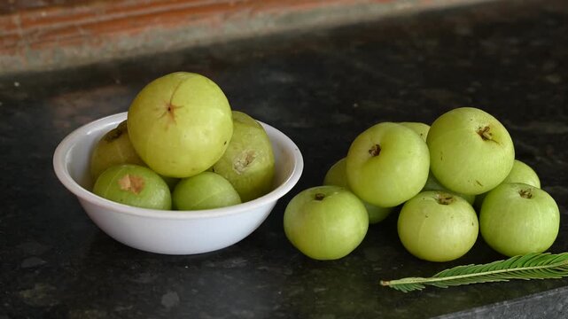Phyllanthus emblica thai fruit herb. Amla (Phyllanthus emblica) fruits in white bowl on black background
