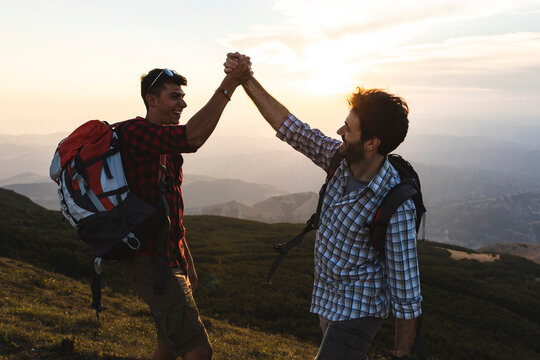 Italy, Monte Nerone, two happy and successful hikers in the mountains at sunset