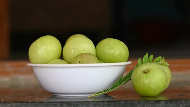 Phyllanthus emblica thai fruit herb. Amla (Phyllanthus emblica) fruits in white bowl on black background