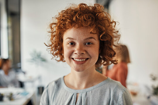 Portrait of a smiling redheaded businesswoman in office