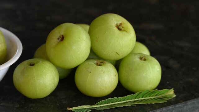 Phyllanthus emblica thai fruit herb. Amla (Phyllanthus emblica) fruits in white bowl on black background