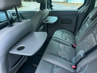 Seats and tables in a modern vehicle interior offer convenience for passengers during travel in an urban area