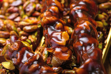 Turkish delight rolls with pistachios and honey glaze on Christmas background.