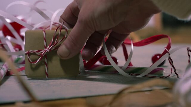 Hands with Christmas gift wrapped in string
