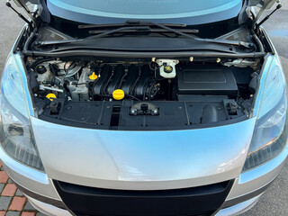 Obraz premium Car engine displayed open at a service area with tools nearby during a morning inspection showing maintenance and repair process